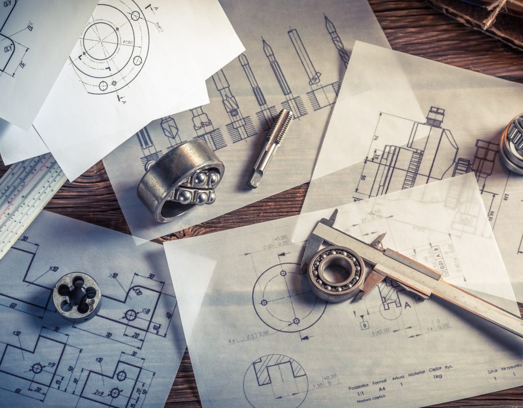 Designing mechanical parts by engineer on old wooden table